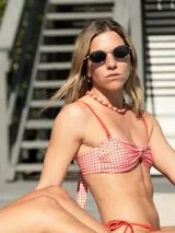 Corpiño de bikini con estampado a cuadros rojos y blancos, con breteles regulables y desmontables, y nudo en la espalda.