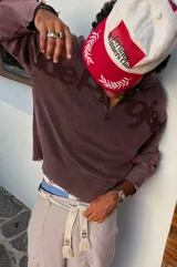 Su&eacute;ter de punto Nude Project, modelo Beast Quarter, color marr&oacute;n con efecto lavado y detalles desgastados en los pu&ntilde;os y la cintura. Cuenta con dise&ntilde;o half-zip, cuello polo y el logo de la marca estampado en el frente y las mangas.