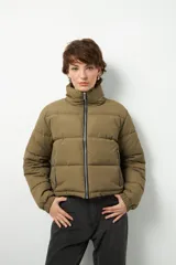 Campera puffer corta color beige de nylon, con cuello alto, cierre frontal y bolsillos laterales con cierre.