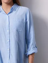 Camisa de lino color beige de la marca Dash, con cuello camisero, cierre frontal con botones, manga larga regulable con presilla y un bolsillo aplicado en el pecho.