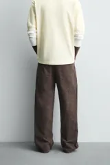 Pantalón de corte baggy fit confeccionado en tejido de algodón con textura y efecto lavado. Presenta diseño de cinco bolsillos, cierre frontal con cremallera y botón.