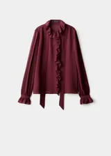 Blusa de viscosa color bordó, con diseño de volantes frontales, cuello redondo con detalle de fular integrado y mangas largas con puños abotonados.