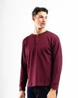 Remera de manga larga estilo henley confeccionada en tejido tipo mini piqué de algodón. Presenta cuello redondo con tapeta de tres botones, puños elásticos y corte recto.