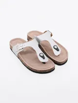 Sandalias planas de dedo tipo Birkenstock, color plateado, con base de corcho y hebilla de ajuste lateral.
