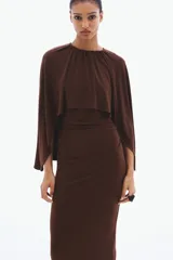 Vestido largo marrón de punto suave, con escote redondo, frunces en los laterales de la cintura y una sección delantera superpuesta con diseño de capa.