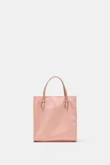 Bolso de mano mini shopper en color rosado con efecto satinado. Cuenta con doble asa de mano y cierre imantado.