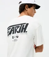 Remera oversized de algodón color blanco, con cuello redondo, mangas cortas y bordado central en relieve con la palabra 'EARTH' en negro.