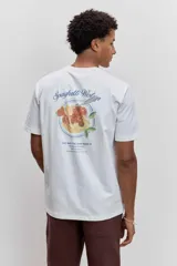 Remera de algodón color marrón chocolate, de corte clásico y cuello redondo, con un pequeño estampado gráfico en el pecho.