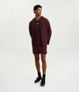 Campera deportiva Get Over de hombre, color bordó, con capucha ajustable, cierre frontal y bolsillos con cremallera. Confeccionada en tejido técnico resistente al agua.