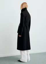 Abrigo largo negro de lana virgen Manteco, de corte recto, con cuello chimenea, cierre delantero de botones, manga larga y forro interior.