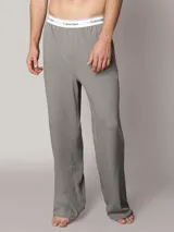 Pantalón de pijama Calvin Klein de corte regular y pierna recta, color gris, confeccionado en punto de algodón suave. Cuenta con bolsillos en las costuras laterales y cinturilla elástica distintiva de la marca.