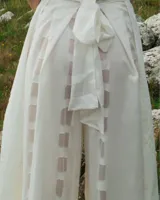 Pantalones palazzo blancos de algodón, con tiras ajustables y calados de gasa.