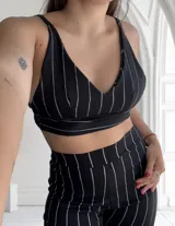 Top negro con rayas verticales blancas, breteles finos y escote en V.