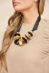 Collar con cinta negra y dije de platillos en carey, negro y dorado.