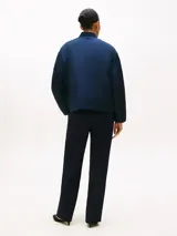 Campera bomber de satén azul marino con acabado repelente al agua y diseño acolchado. Presenta cuello estilo béisbol de punto canalé, cierre frontal de cremallera y logo de Tommy Hilfiger bordado en fuente script en el pecho.