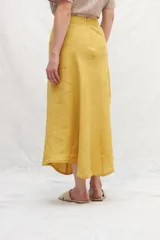 Falda midi color mostaza, de lino, con corte evasé y cintura alta.