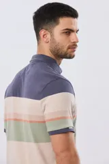 Remera polo de manga corta con diseño de franjas horizontales en tonos azul, beige, verde y terracota. Presenta cuello camisero con cierre frontal de dos botones y un pequeño bordado en el pecho.