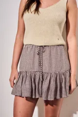 Minifalda con estampado de cuadros vichy en tonos marrón y blanco, con cintura elástica fruncida, cordón ajustable y volado en el ruedo.