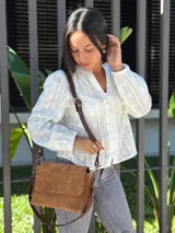 Cartera bandolera de cuero gamuzado color camel, con solapa frontal y cierre principal. Incluye dos correas desmontables, una corta y una larga regulable, y cuenta con bolsillo interior.