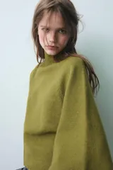 Jersey de punto color verde oliva, con cuello subido y mangas anchas tipo acampanadas.