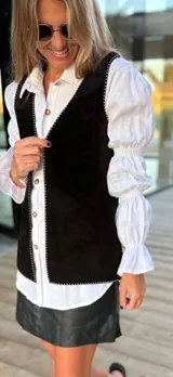 Chaleco de cuero marrón con detalle de tachas en el contorno.