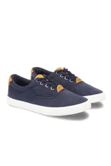 Championes de lona azul marino con cordones y suela blanca, con detalles en color tostado en la lengüeta y el talón.