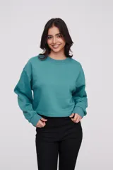 Buzo de cuello redondo y manga larga, con diseño liso y corte a la cintura.