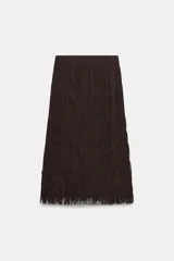 Falda midi de tiro medio, color marrón oscuro, con detalle de flecos en todo el ruedo y textura plisada o arrugada en capas horizontales. Cierre con cremallera oculta en costura.