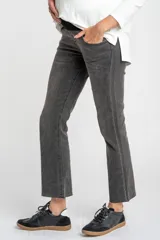 Pantalón de jeans gris oscuro, de corte flare y tiro medio, con ruedo desflecado.