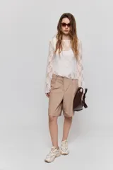Bermuda sastrera de color beige, con diseño de tiro medio, pinzas delanteras y calce relajado.