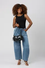 Cartera estilo pocket bag de cuero sintético con acabado brillante, cuenta con bolsillos frontales con cordones ajustables y correa de hombro integrada.