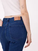 Jean de corte recto con costuras verticales decorativas en el frente, tiro medio y cierre frontal con botón metálico.