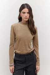 Polera de terciopelo color dorado, con cuello alto y mangas largas.