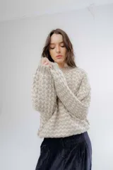 Buzo de punto grueso con diseño bicolor en patrón geométrico, de calce holgado y mangas largas.