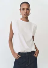 Camiseta blanca de algodón con hombreras, cuello redondo y mangas cortas estructuradas.