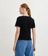 Top de manga corta ajustado al cuerpo, color marrón oscuro, con cuello redondo y bordes festoneados en color crema o beige claro.