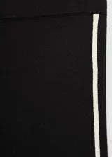 Pantalón de punto fino con diseño acampanado y tiro alto. Presenta una cintura con elástico y detalle de pipping en contraste a lo largo de las piernas.