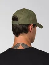 Gorra de béisbol de color verde oliva con visera curvada y logotipo de Caterpillar bordado en negro en la parte frontal. Cuenta con tira trasera ajustable con cierre metálico.