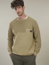 Sweater de algodón con cuello redondo, diseño de tejido combinado con textura acanalada en la parte superior y bolsillo frontal pequeño con etiqueta decorativa.