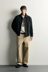 Sobrecamisa negra de corte relaxed fit, confeccionada en tejido de algodón con elasticidad. Cuenta con cuello solapa, manga larga con puño abotonado, bolsillos de vivo en la cadera y cierre frontal de botonadura.