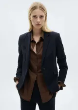 Chaqueta tipo blazer de corte slim, color azul marino, con cuello de solapa, cierre frontal de un botón y dos bolsillos laterales con solapa.