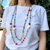 Collar largo con cadena plateada de eslabones y piedras de coral, turquesa y nácar. Incluye dijes en forma de corazón de nácar.