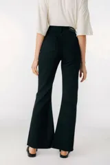 Pantalón jean tiro alto de corte flared, color celeste claro, con diseño ajustado en las piernas y aberturas en el dobladillo inferior.