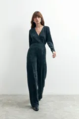 Mono largo de punto color gris oscuro con lurex, escote en V y cierre frontal con un botón. El pantalón es de corte palazzo.