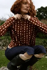 Cardigan reversible de punto con diseño de rombos pequeños en contraste. Presenta cuello redondo, cierre frontal con botones y puños con terminación festoneada.