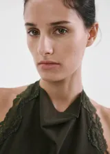 Top verde militar de diseño recto, con cuello halter y detalles de encaje en los bordes. Confeccionado en algodón con puntilla combinada.