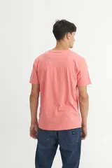 Remera de algodón color coral con cuello redondo, mangas cortas y estampa frontal con el texto 'SOLID CREW' y un diseño gráfico de un volcán en tonos naranja.
