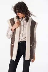 Chaleco reversible de cuero napalan color marrón con interior de corderito color crema. Tiene silueta holgada, terminaciones a la vista y bolsillos laterales.