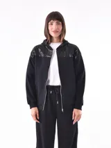 Campera deportiva negra con capucha, cierre frontal y apliques de lentejuelas en los hombros.