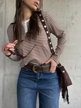 Remera de manga larga a rayas horizontales en tono tostado y blanco, con cuello redondo y cartera de botones frontal.